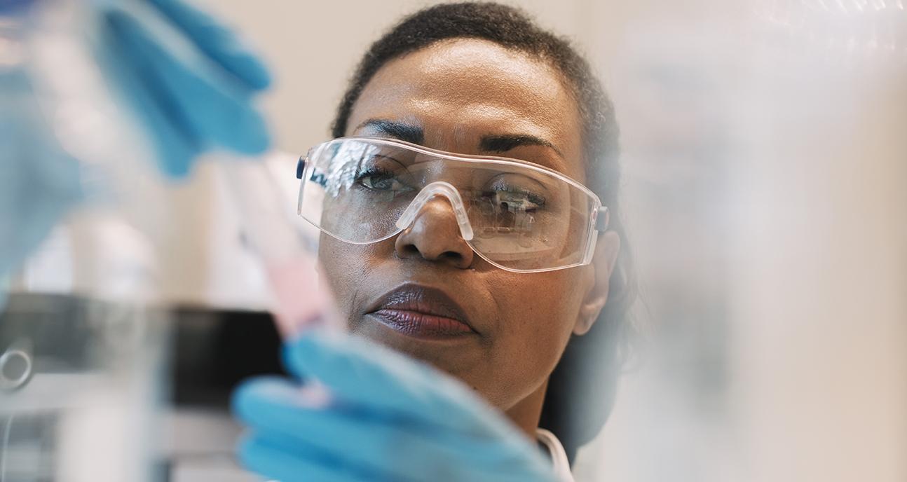 Scientist works with vial in lab setting