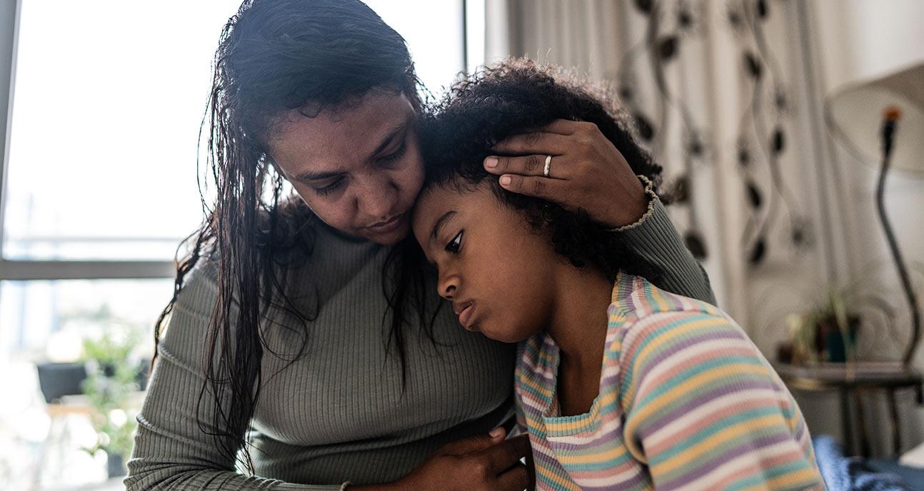 A parent cradling a sick child